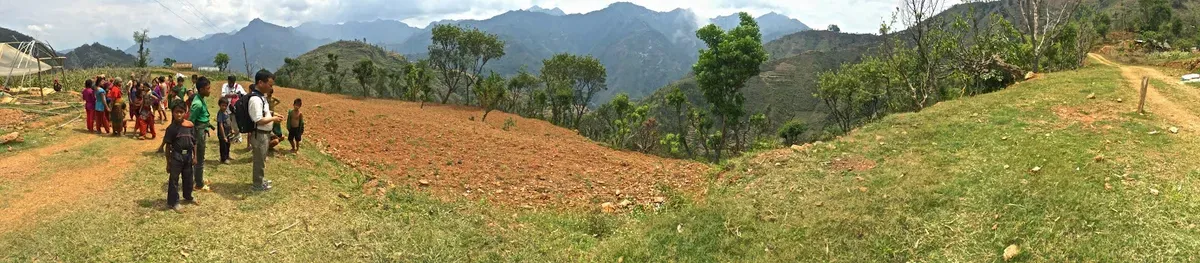 People gathered on a terrace overlooking a mountain valley