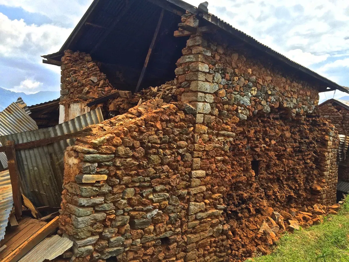 Stone building with a collapsed wall and rubble below
