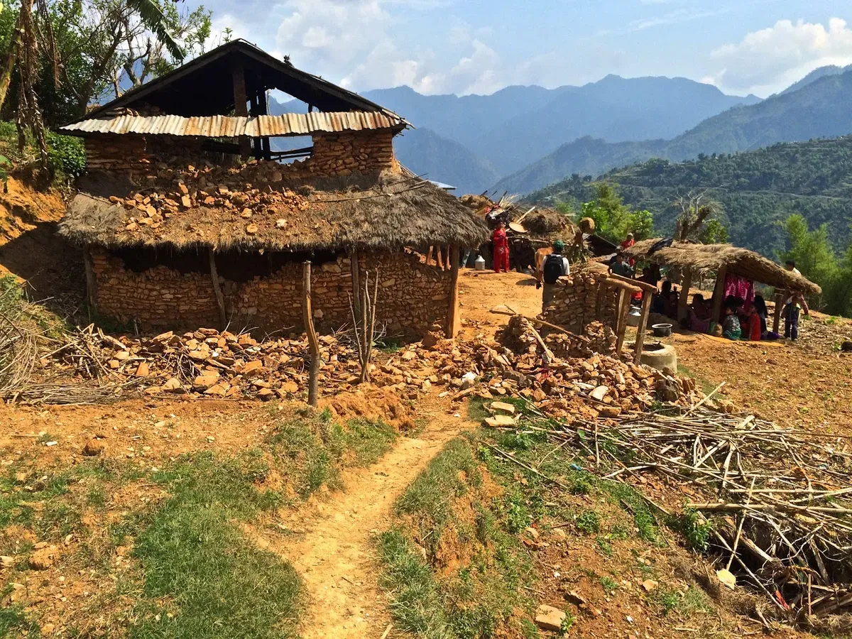 Damaged village houses with mountains in the distance