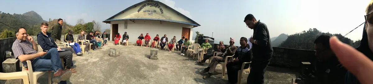 Visitors and residents gathered outside a community building in the hills