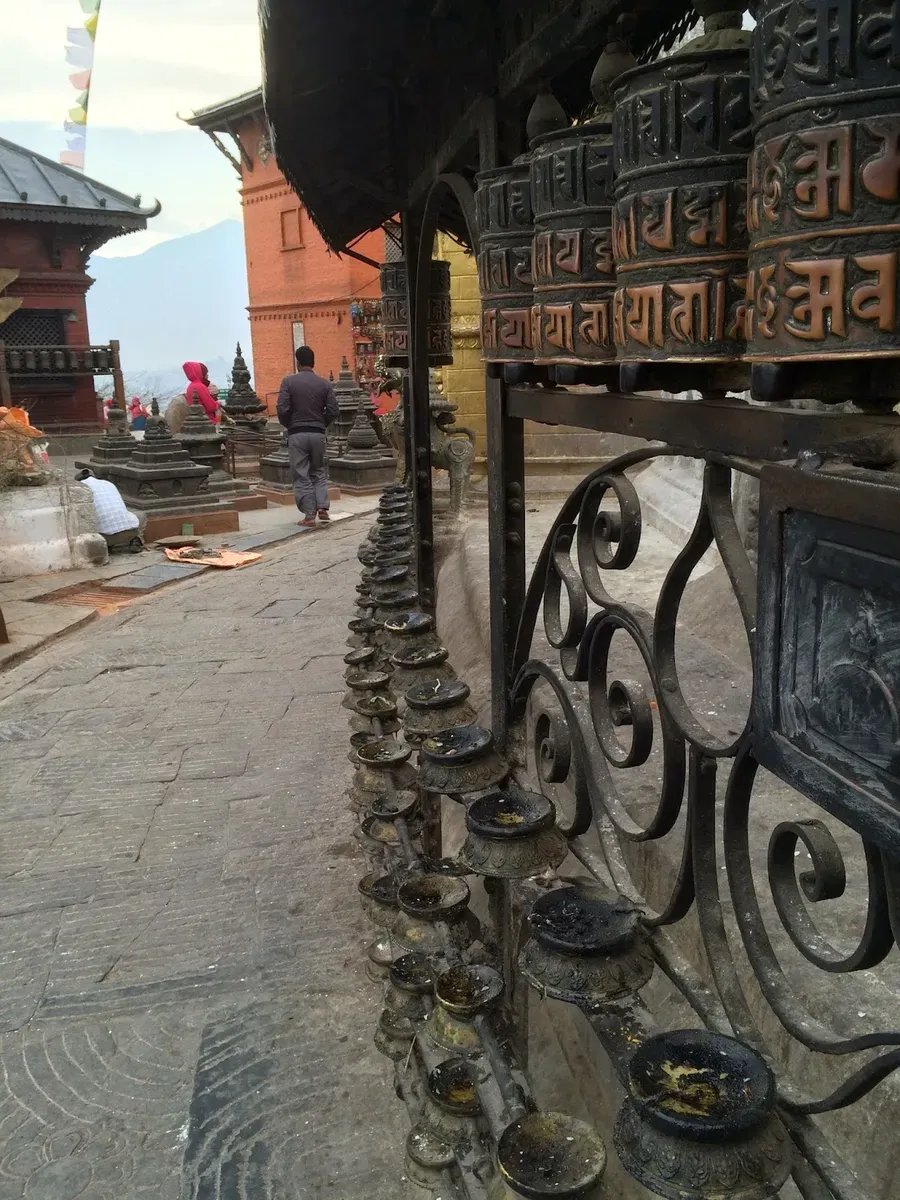 Prayer wheels along a temple walkway